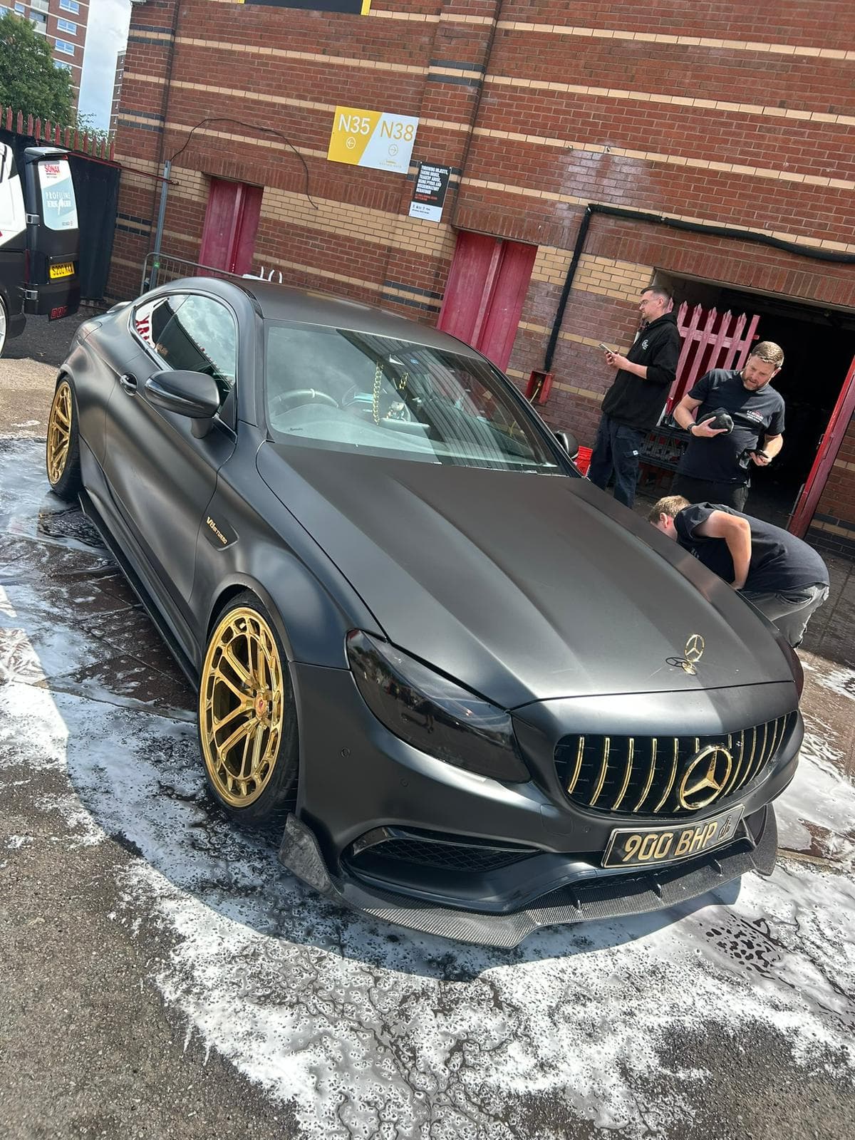 Matte grey Mercedes AMG C63 with gold wheels after detail