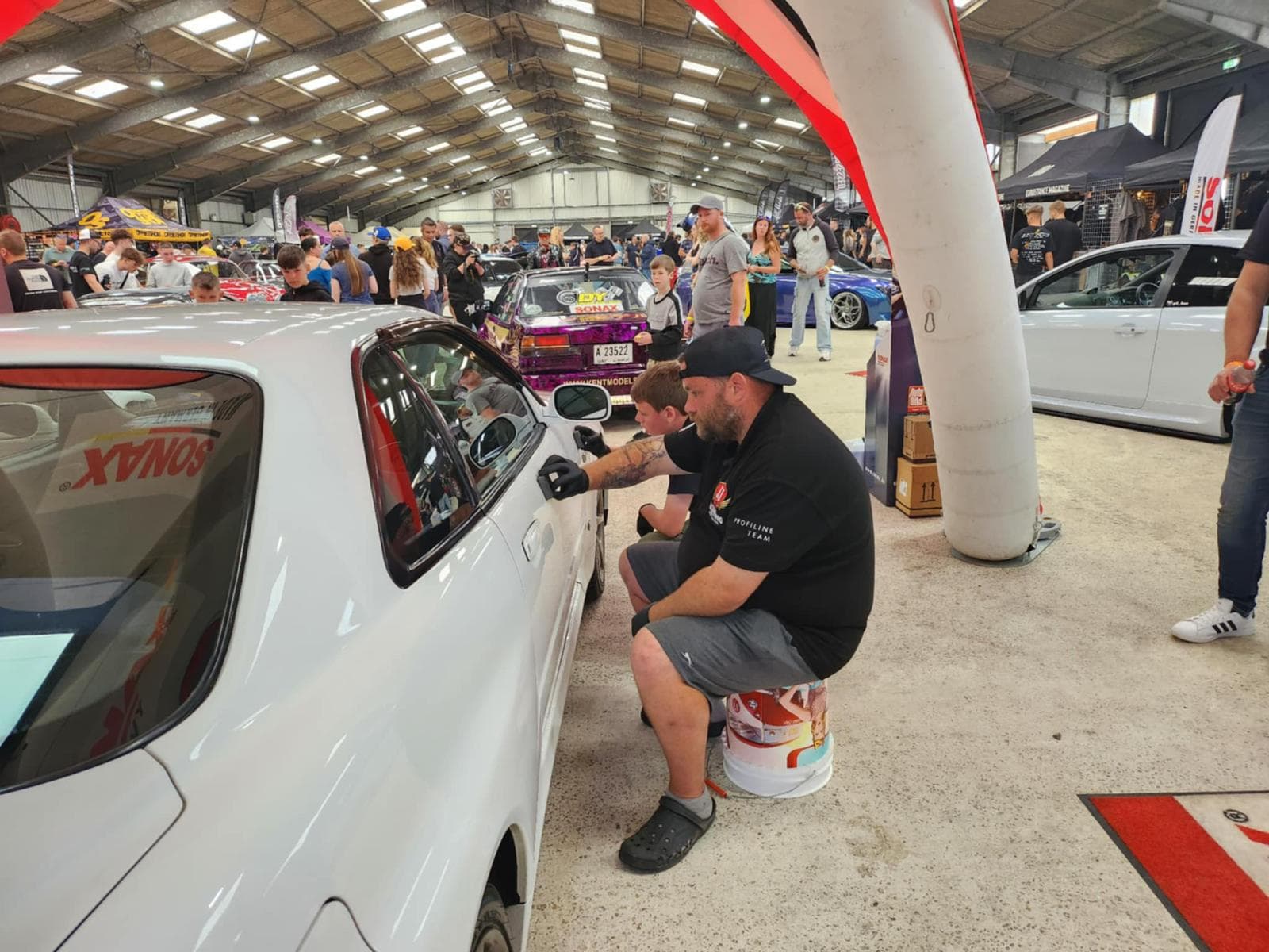 JJ team member working on car at show